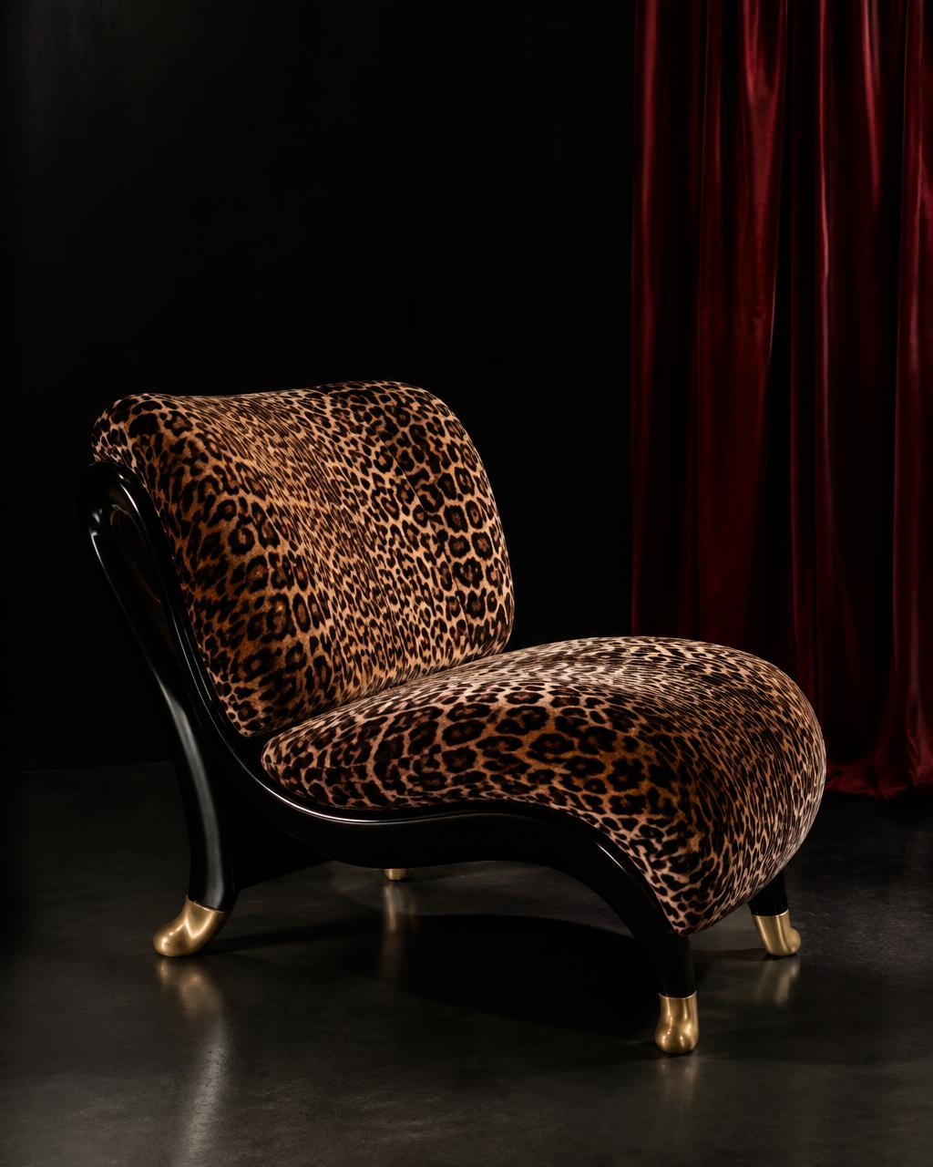 Leopard velvet lounge chair with ebony lacquer frame in a dark room