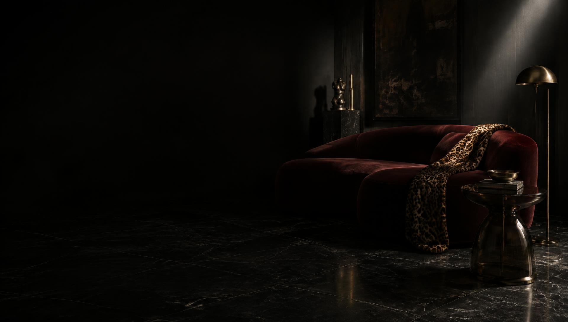 Oxblood velvet sofa with leopard throw in a black marble room